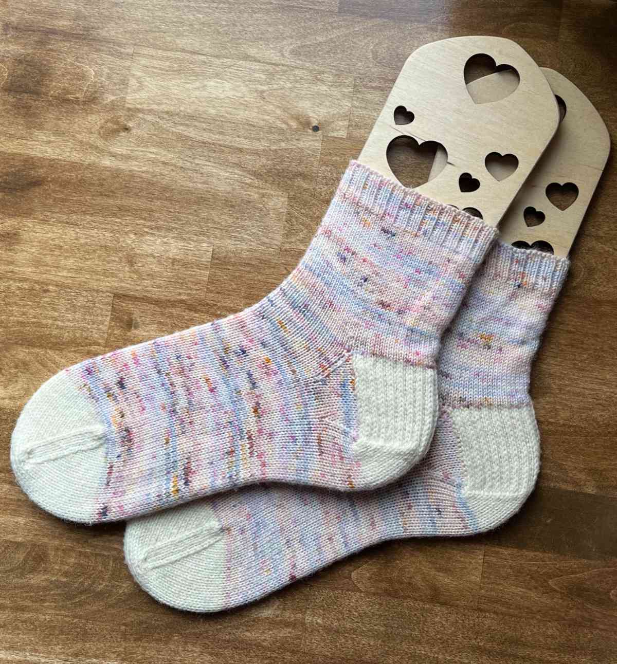 A pair of hand knit socks on sock blockers.